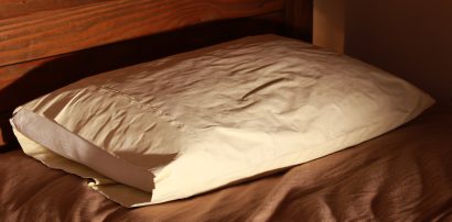 A soft pillow on a comfortable bed, representing healthy sleep