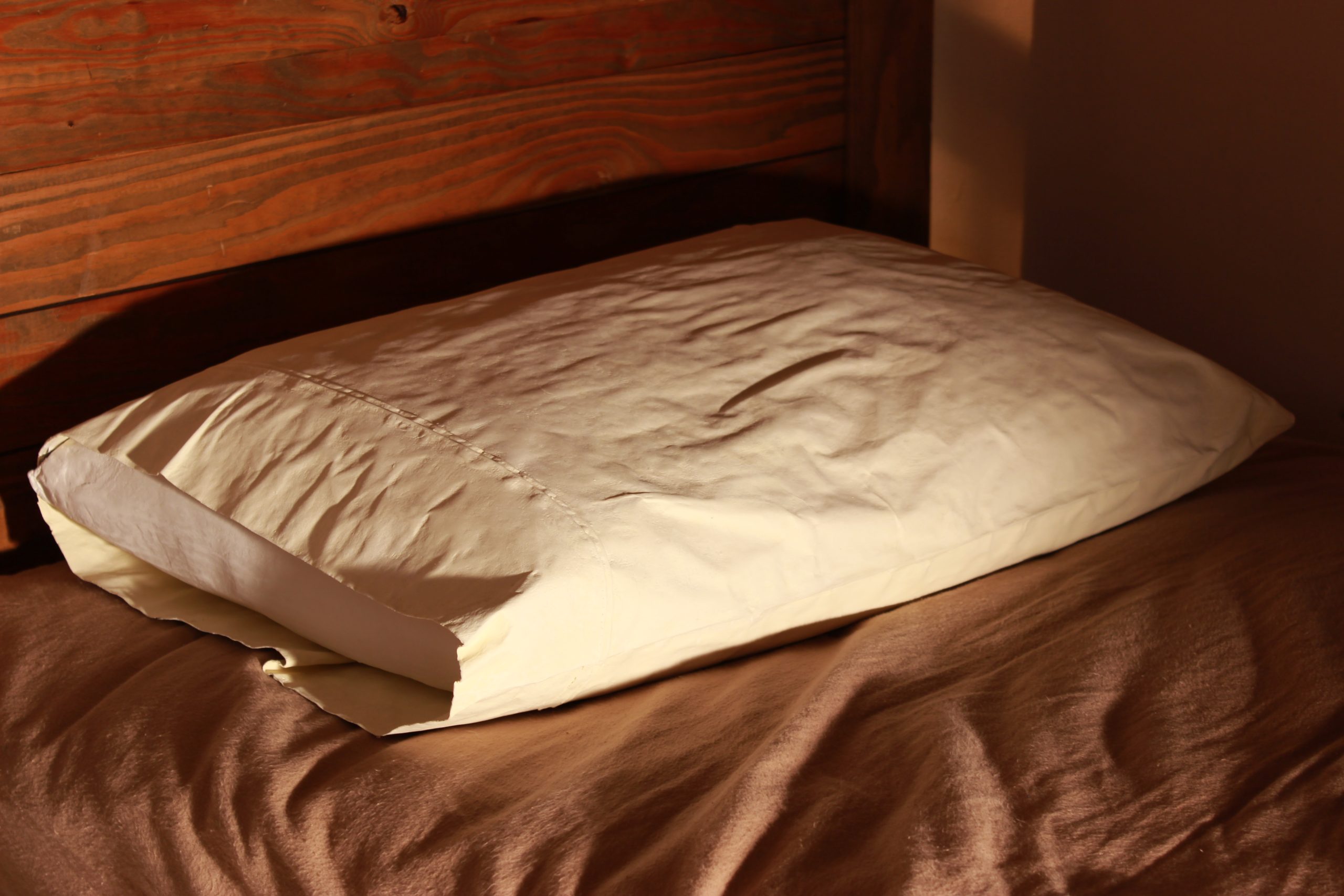 A soft pillow on a comfortable bed, representing healthy sleep