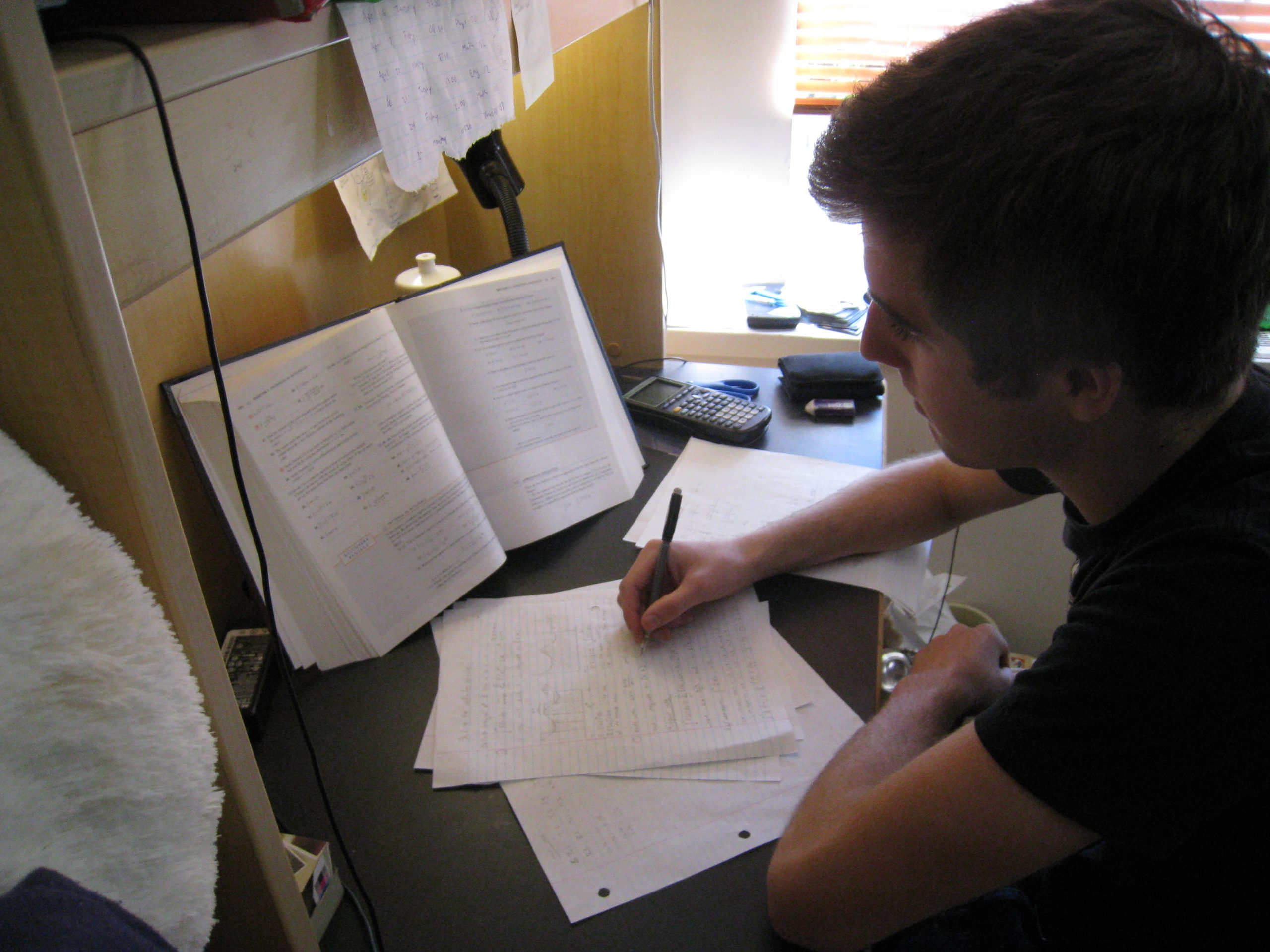 Best Nootropics for Studying: A Complete Guide 2 A student studying with an open textbook, taking notes at a desk