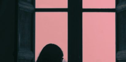 Woman calmly standing by a window representing mood and mental health considerations with Armodafinil