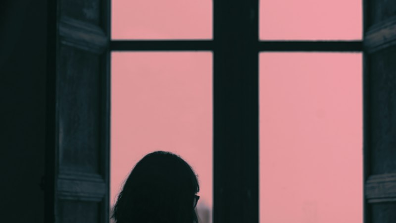 Woman calmly standing by a window representing mood and mental health considerations with Armodafinil