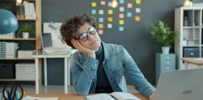 Tired person resting head on hand representing Armodafinil withdrawal effects