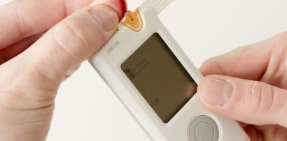 Person testing blood glucose with a glucometer representing Metformin for type 2 diabetes