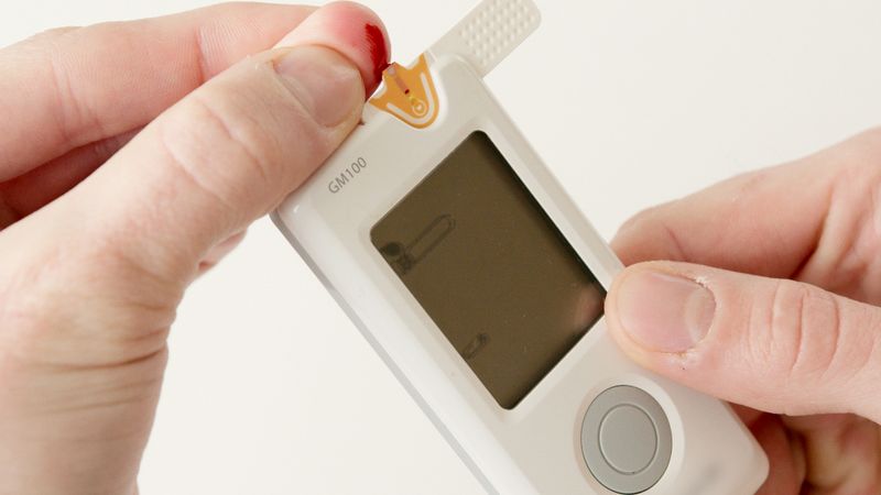 Person testing blood glucose with a glucometer representing Metformin for type 2 diabetes